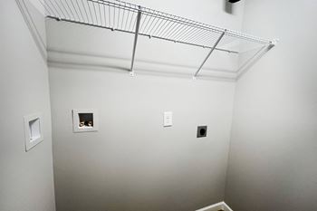 A room with white walls and a wire rack on the ceiling